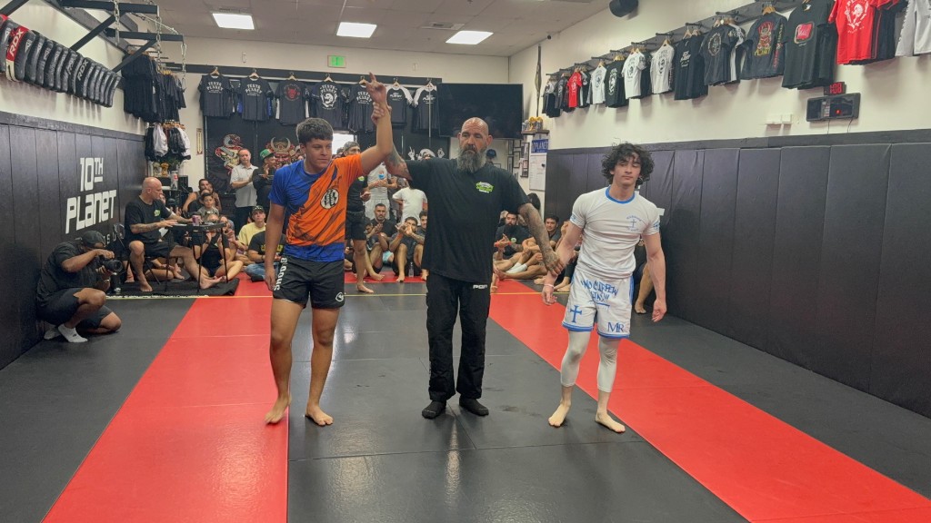 C3 student with hand raised in victory at a 10th Planet Jiu-Jitsu competition